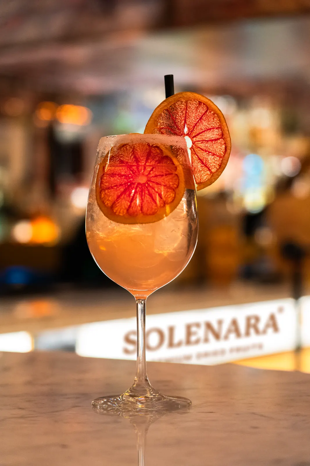 Spritz mit getrockneten Pink-Grapefruit-Scheiben in einer Lounge
