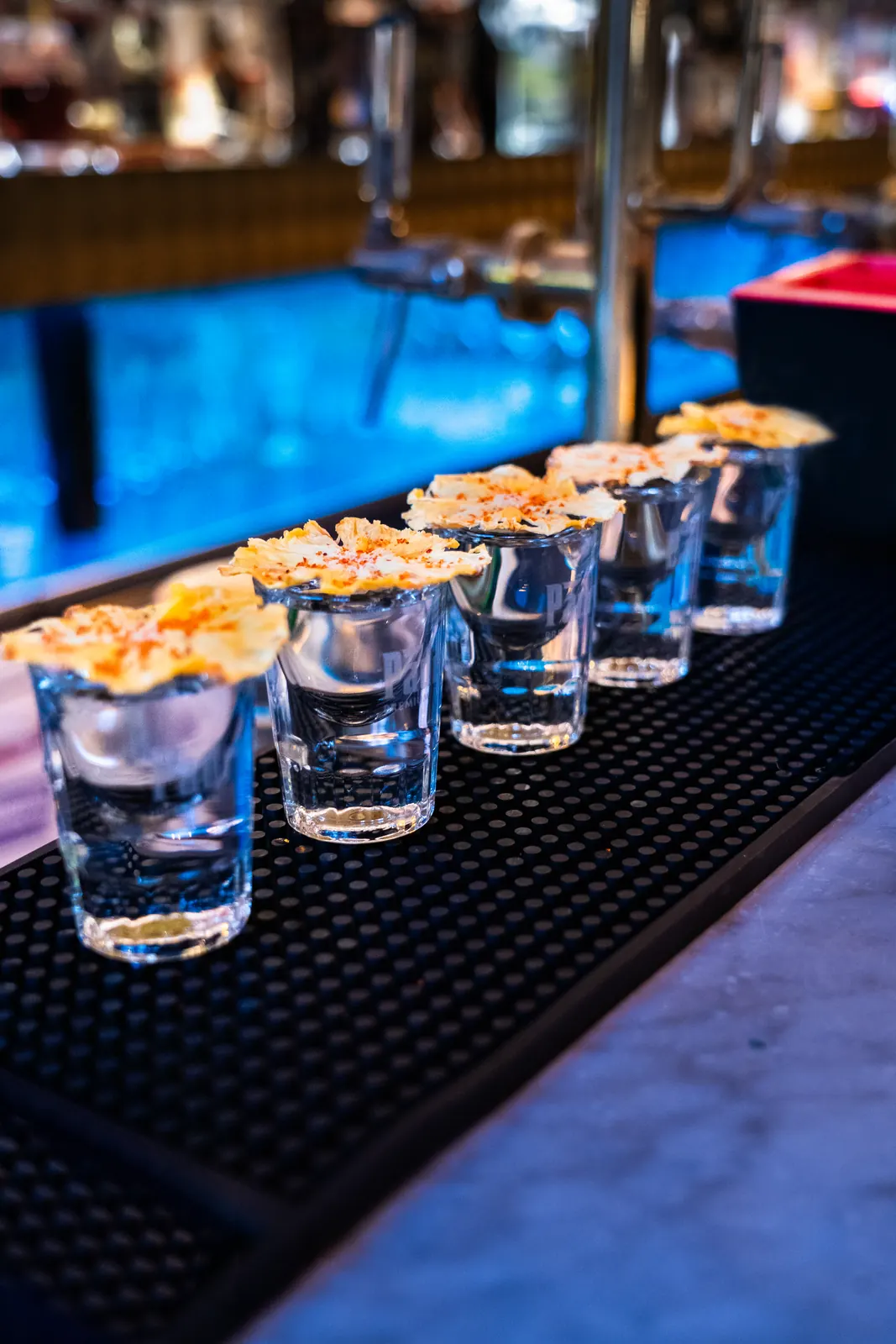 Reihe von Shots mit getrockneten Solenara-Ananasscheiben an einer Bar