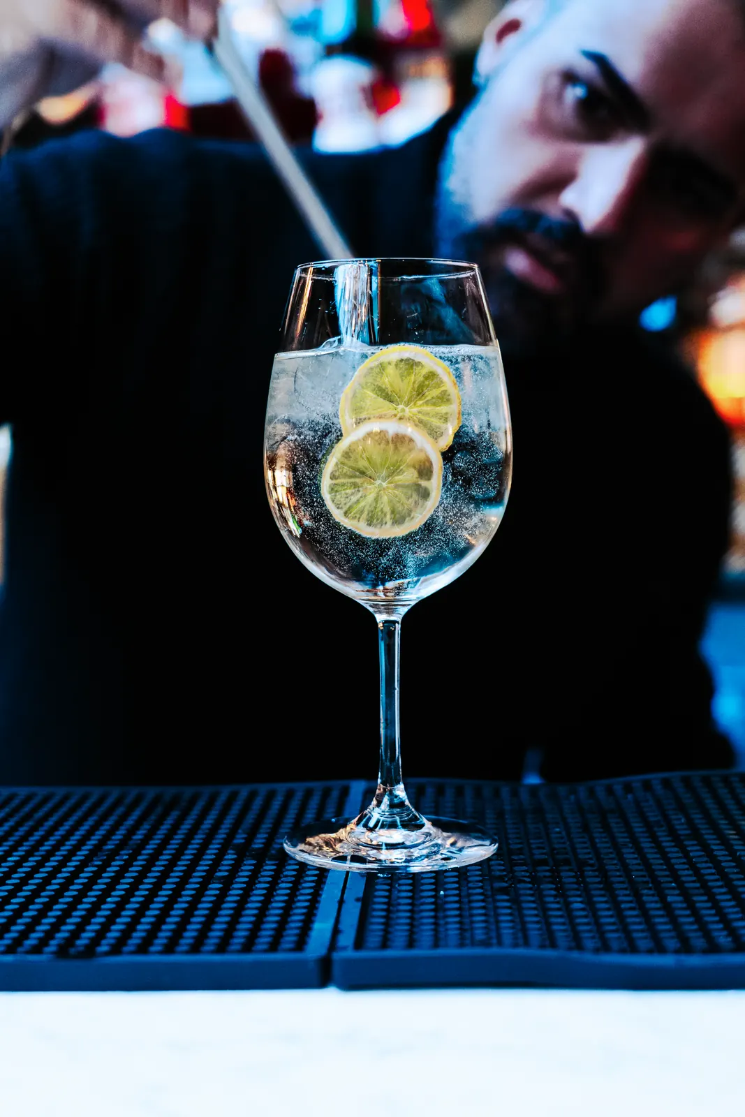 Weißer Spritzer mit getrockneten Zitronenscheiben an der Bar
